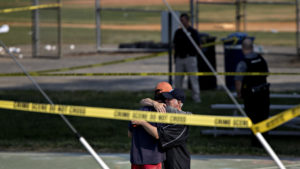 Two people hug in an area blocked off by police crime scene tape in Alexandria, Va., after a shooting during a congressional baseball practice Wednesday.